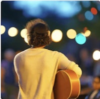 a man playing an acoustic guitar at night